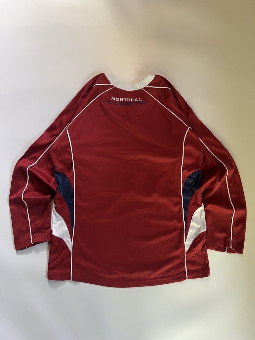 Montreal Alouettes CFL Jersey (Category: Activewear) located in Baler. Submitted by allthrifted31 (Listing ID 1462960558, Image 2). Description: - Montreal Alouettes CFL Jersey - Color: Burgundy with white and navy accents - Features team logo on the front - 'Montreal Alouettes' text on the back collar - Designed for comfort and durability - Perfect for any CFL fan.