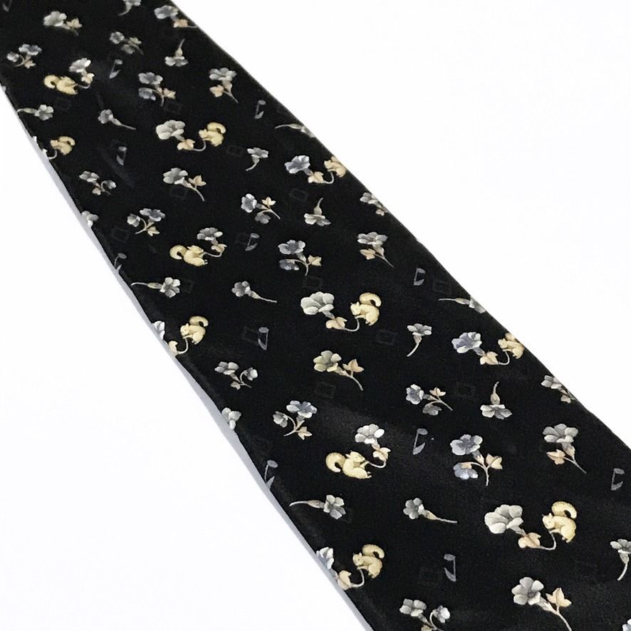 Nicole Miller Black Floral Pattern Neck Tie (Category: Ties) located in Taguig. Submitted by retrogaze (Listing ID 1463042067, Image 3). Description: This 100% silk necktie by Nicole Miller features a solid black base with a smooth, soft-sheen finish. The body displays a charming novelty pattern of delicate mini floral blossoms in periwinkle blue and cream, interspersed with small beige squirrels and floating musical notes. Brand Overview: Nicole