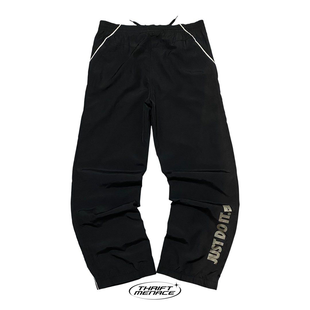 Nike Black Track Pants "Just Do It" Logo (Category: Joggers) located in Manila. Submitted by urboycee (Listing ID 1463091635, Image 3). Description: - Classic black Nike track pants - Iconic Nike Swoosh logo on left leg - "Just Do It" graphic on right leg - Comfortable elastic waistband with adjustable drawstring - Stylish white piping detail along the sides - Versatile for everyday wear or athletic activities.