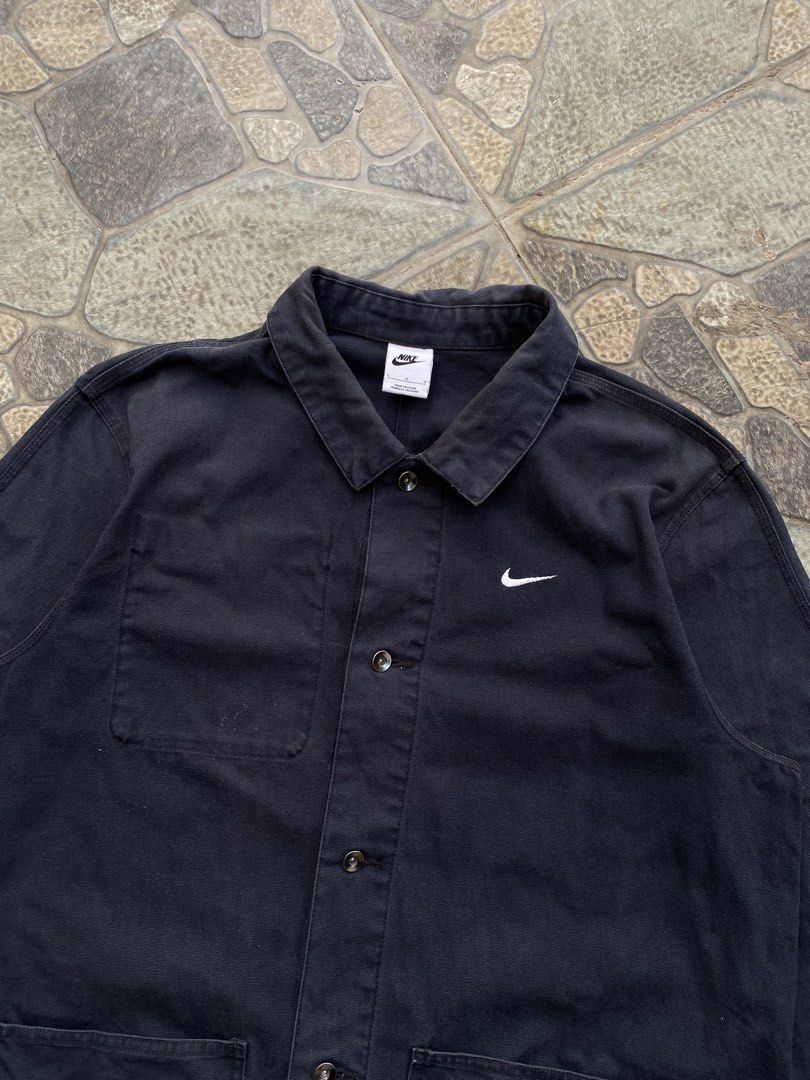 Nike Black Workwear Jacket (Category: Coats, Jackets and Outerwear) located in Alicia. Submitted by wunna1_sham (Listing ID 1463000638, Image 2). Description: - Classic black Nike jacket - Workwear style with button-up front - Two chest pockets - Two lower pockets - Simple Nike swoosh logo on chest - Ideal for layering.