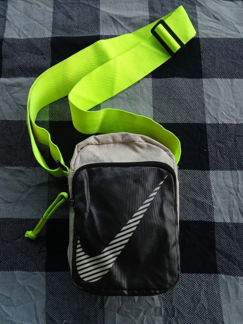Nike Crossbody Bag Neon Strap (Category: Cross-body Bags) located in Manila. Submitted by timog_high_ice_v2 (Listing ID 1463114798, Image 1). Description: - Nike crossbody bag - Color: Black and grey body - Strap: Bright neon green, adjustable - Design: Large white Nike swoosh - Closure: Zipper with small loop pull - Functionality: Ideal for carrying essentials.