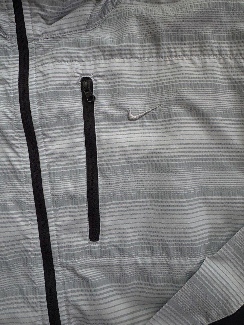 Nike Golf Lightweight Striped Hooded Jacket XL (Category: Coats, Jackets and Outerwear) located in Pasig City. Submitted by kutleyn (Listing ID 1462885492, Image 3). Description: - Lightweight Nike Golf Jacket - Size: XL - Color: Grey and white stripe pattern with black accents - Features: Zippered chest pocket, hood - Ideal for: Golf or casual wear.