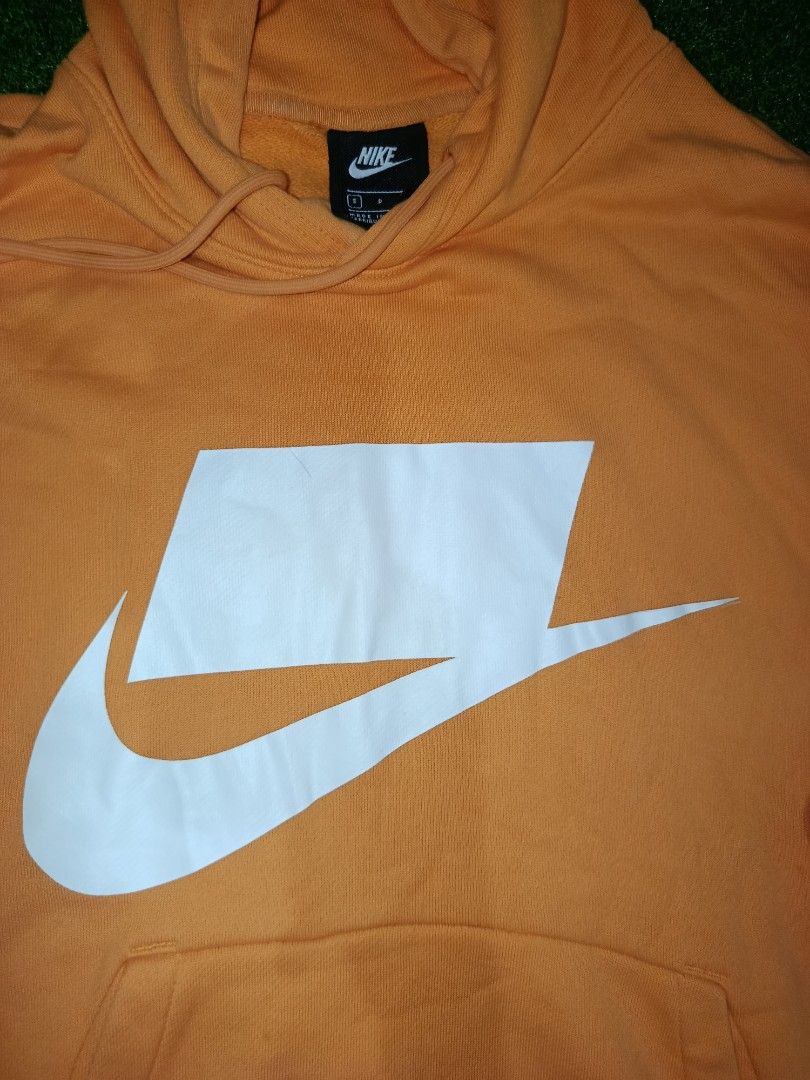 NIKE NSW NSP HOODIE JACKET (Category: Hoodies) located in Valenzuela. Submitted by d.repolthrift (Listing ID 1463010076, Image 3). Description: - Orange Nike hoodie -Size:Small -Width:22 -Length:25 -Good as new condition -Fresh from bale -Wash dirt - Large white swoosh logo on front - Front pocket for convenience - Adjustable drawstring hood - 'NOT A SAMPLE' graphic on the back - Ideal for everyday casual wear.