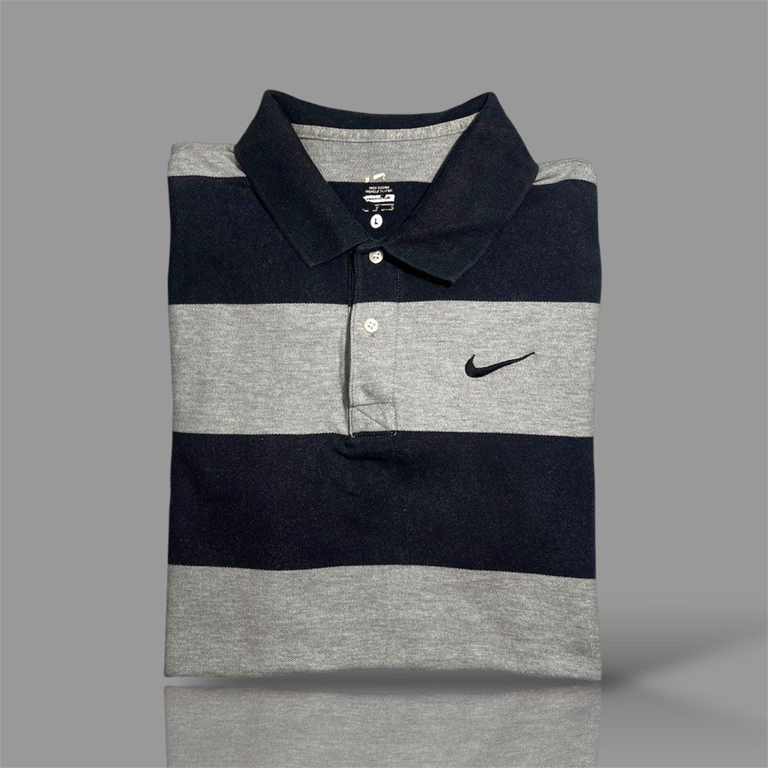 Nike Striped Polo Shirt (Category: Tshirts & Polo Shirts ) located in Cavite. Submitted by allen19deg89858 (Listing ID 1462999590, Image 1). Description: - Classic Nike polo shirt - Navy and grey stripe design - Small Nike swoosh logo on chest - Button-up collar - Size: Large (L) - Ideal for casual outings or golf.