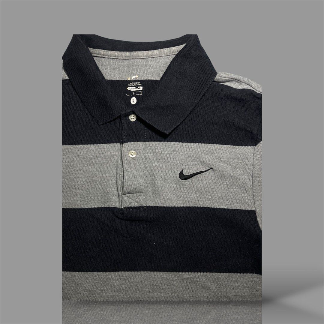 Nike Striped Polo Shirt (Category: Tshirts & Polo Shirts ) located in Cavite. Submitted by allen19deg89858 (Listing ID 1462999590, Image 3). Description: - Classic Nike polo shirt - Navy and grey stripe design - Small Nike swoosh logo on chest - Button-up collar - Size: Large (L) - Ideal for casual outings or golf.