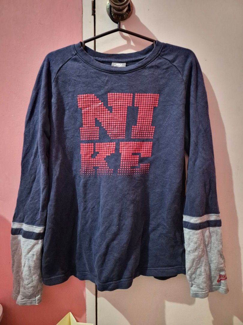 Nike Sweatshirt (Category: Coats, Jackets and Outerwear) located in Bulacan. Submitted by mrk_mdl (Listing ID 1463031872, Image 1). Description: - Navy blue Nike sweatshirt - Red pixelated Nike logo on the front - Grey sleeves with double stripes - Small red Nike logo on the right sleeve cuff - Ideal for casual wear.
