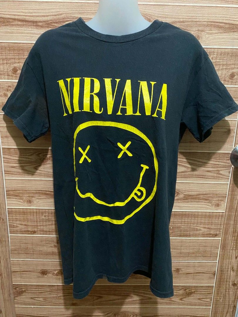 Nirvana graphic tee (Authentic) (Category: Activewear) located in Binan City. Submitted by katespanie (Listing ID 1462946349, Image 1). Description: Medyo visible ang kaunting lukot o wrinkles sa tela dahil siguro sa pagka-display sa mannequin, pero madali naman itong madaanan ng plantsa.Pansinin na ang itim na kulay ng tela ay medyo faded o may kaunting pagka-washed out na, na normal naman para sa mga pre-loved o vintage band tees. Still in good