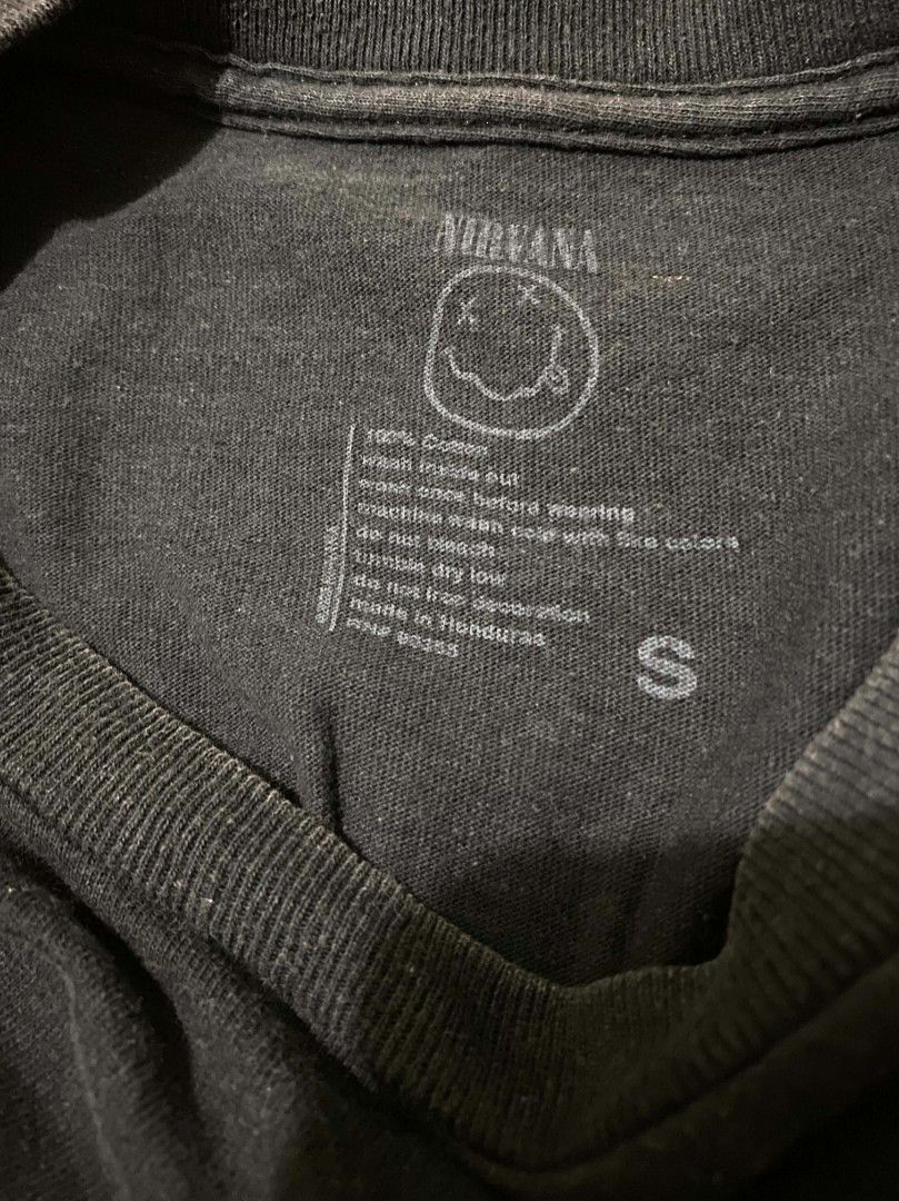 Nirvana graphic tee (Authentic) (Category: Activewear) located in Binan City. Submitted by katespanie (Listing ID 1462946349, Image 2). Description: Medyo visible ang kaunting lukot o wrinkles sa tela dahil siguro sa pagka-display sa mannequin, pero madali naman itong madaanan ng plantsa.Pansinin na ang itim na kulay ng tela ay medyo faded o may kaunting pagka-washed out na, na normal naman para sa mga pre-loved o vintage band tees. Still in good