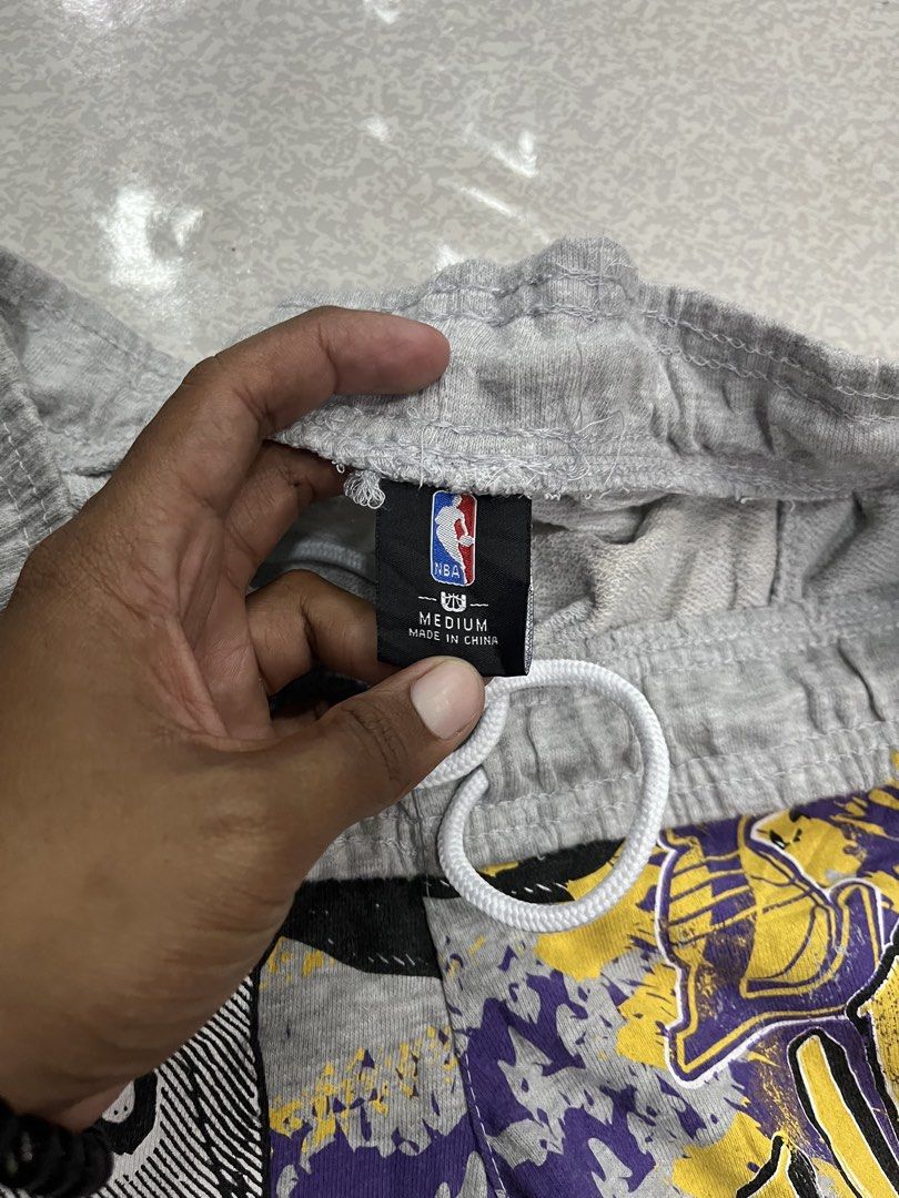 Officially Licensed NBA Merchandise (Category: Shorts) located in Manila. Submitted by becarria_thrift23 (Listing ID 1463016705, Image 2). Description: Bold 90s-style graphic mashup featuring King James #23 and retro Los Angeles Lakers logos. Features comfortable french terry fleece, elastic waistband with drawstrings, and side pockets.