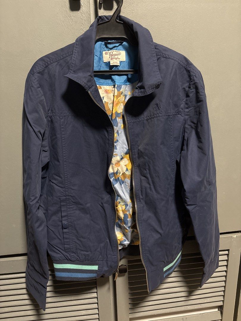 Original Penguin Navy Bomber Jacket with Floral Lining (Category: Coats, Jackets and Outerwear) located in Manila. Submitted by allenv.2k (Listing ID 1463063553, Image 1). Description: - Navy blue bomber jacket by Original Penguin - Features a stylish floral print lining - Ribbed cuffs and hem with classic stripe details - Full zip-up front with a collar - Ideal for everyday casual wear.