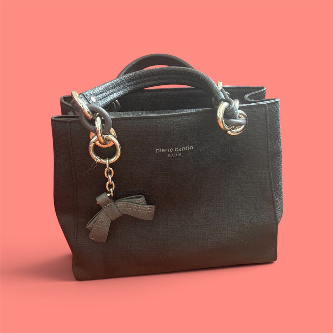 Pierre Cardin Black Handbag with Bow Charm (Category: Tote Bags) located in Batangas. Submitted by missraee (Listing ID 1460970174, Image 1). Description: - Brand: Pierre Cardin - Color: Black - Design: Classic and simple with a cute bow charm on the side - Features: Top handles for easy carrying - Interior: Clean and well-maintained - Versatile: Suitable for everyday wear or a night out No sling. Super ganda pa for everyday use as a handbag.