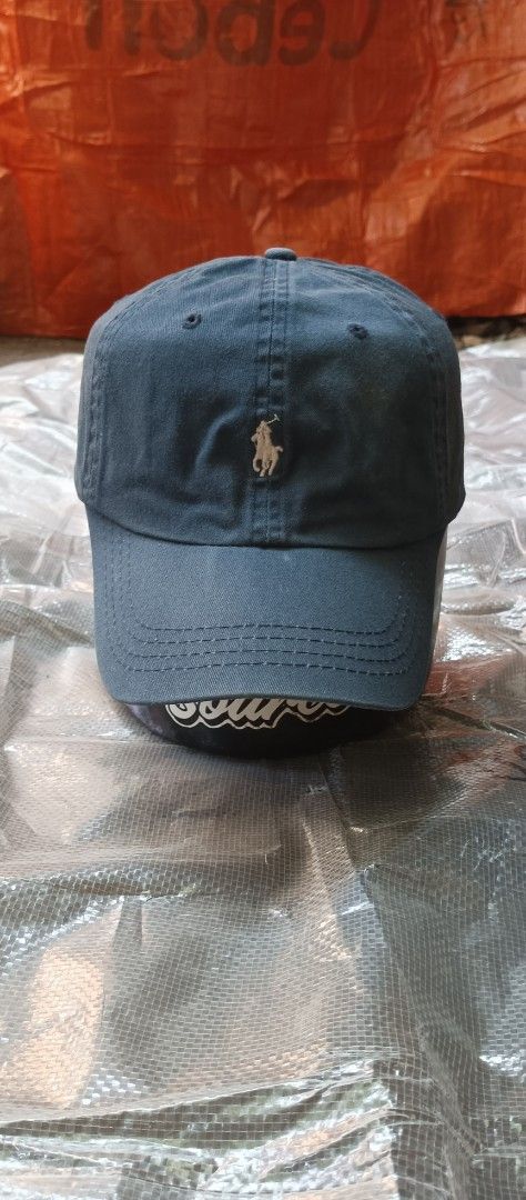 Polo Ralph Lauren Baseball Cap Navy Blue (Category: Caps & Hats) located in Quezon City. Submitted by mangthrift (Listing ID 1463038218, Image 1). Description: - Classic navy blue Polo Ralph Lauren baseball cap - Iconic polo player logo embroidered on the front - 'POLO' embroidered on the back - Adjustable leather strap for a comfortable fit Adult Size - Perfect for everyday wear - Need wash only.