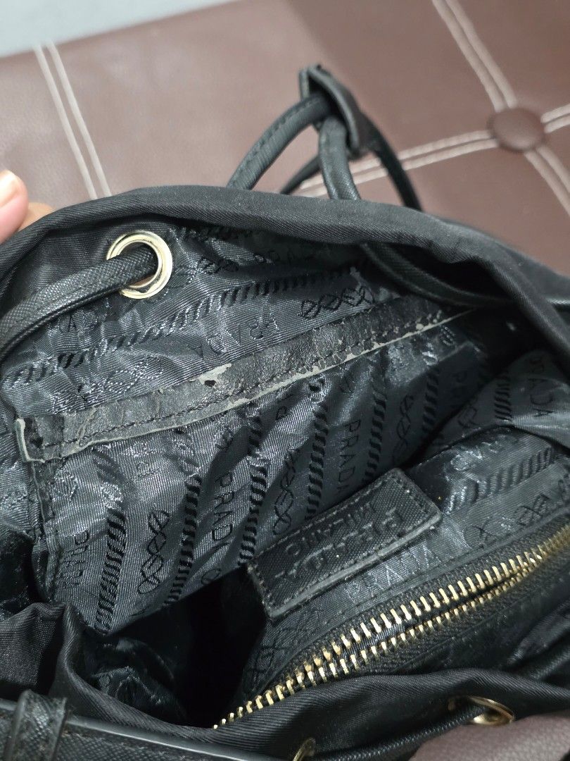 Prada Duet Nylon Bucket Bag (Category: Luxury Bags & Wallets) located in Manila. Submitted by decluttaro (Listing ID 1463076536, Image 3). Description: NGA Prada black nylon bag. Features drawstring closure, flap top, front zip pocket, and adjustable straps. Interior has Prada logo lining. Minor wear on inside lining near zipper as pictured..