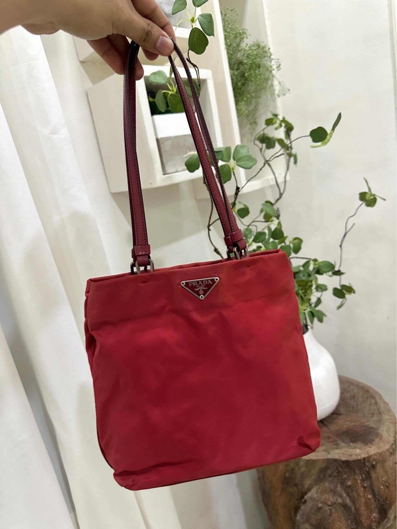 Prada Red Nylon Shoulder Bag Code: cdr84 (Category: Luxury Bags & Wallets) located in Quezon City. Submitted by janine.ee (Listing ID 1462904359, Image 1). Description: - Authentic Prada shoulder bag - Durable red nylon with leather trim - Classic triangular Prada logo hardware - Ideal size for everyday essentials - Comfortable shoulder straps - Versatile addition to your collection - Clean interior - Ready for a new owner - With Entrupy .