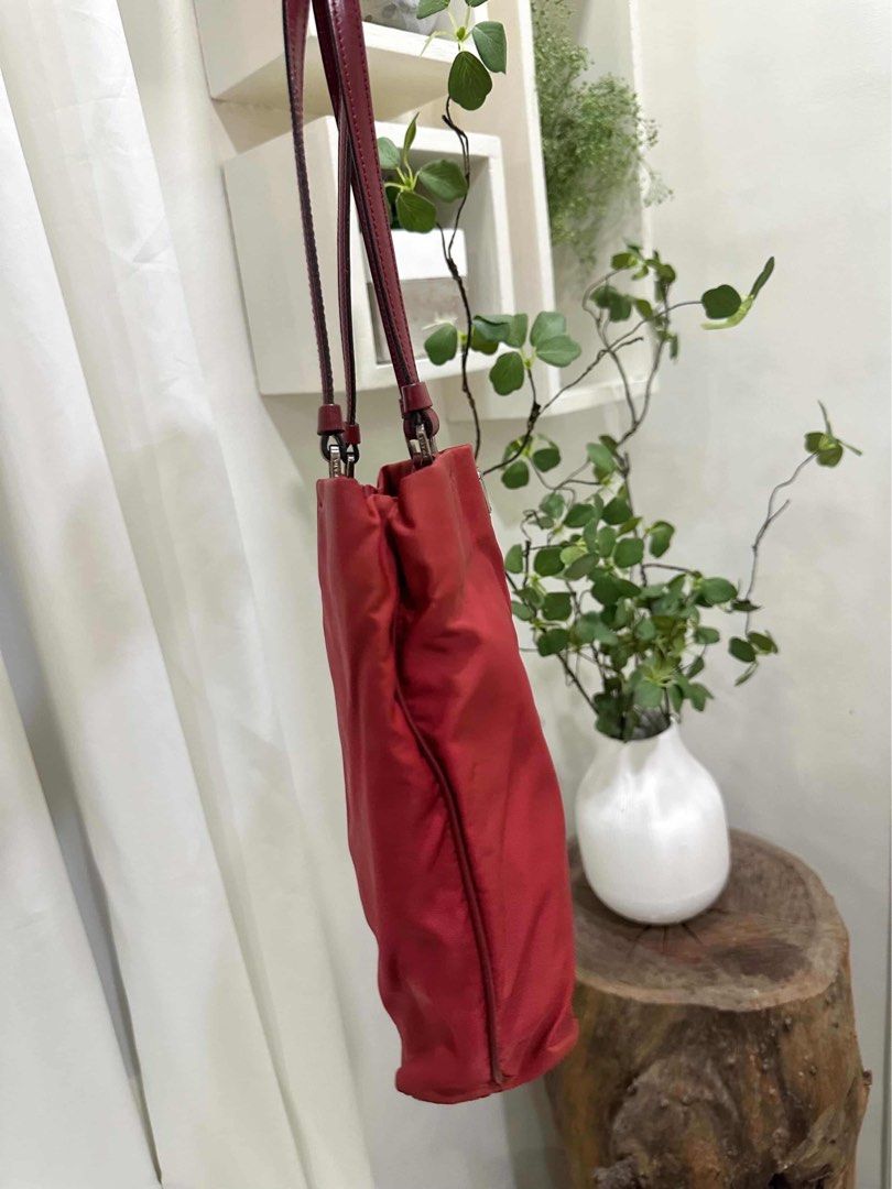 Prada Red Nylon Shoulder Bag Code: cdr84 (Category: Luxury Bags & Wallets) located in Quezon City. Submitted by janine.ee (Listing ID 1462904359, Image 3). Description: - Authentic Prada shoulder bag - Durable red nylon with leather trim - Classic triangular Prada logo hardware - Ideal size for everyday essentials - Comfortable shoulder straps - Versatile addition to your collection - Clean interior - Ready for a new owner - With Entrupy .