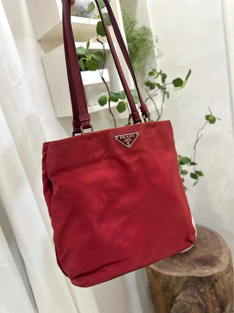 Prada Red Nylon Shoulder Bag Code: cdr84 (Category: Luxury Bags & Wallets) located in Quezon City. Submitted by janine.ee (Listing ID 1462904359, Image 2). Description: - Authentic Prada shoulder bag - Durable red nylon with leather trim - Classic triangular Prada logo hardware - Ideal size for everyday essentials - Comfortable shoulder straps - Versatile addition to your collection - Clean interior - Ready for a new owner - With Entrupy .