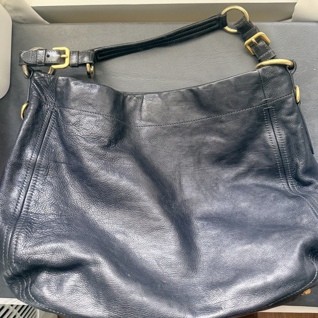 Prada Vitello Black Leather Hobo Shoulder Bag (Category: Luxury Bags & Wallets) located in Makati City. Submitted by quenniebee (Listing ID 1462896976, Image 2). Description: - Authentic Prada hobo bag - Black leather - Gold hardware details - Soft leather with a nice slouch - Interior with multiple compartments and zip pockets - Ideal everyday work bag, fits a laptop - Shows some signs of wear, but plenty of life left - Vintage, no white tag any