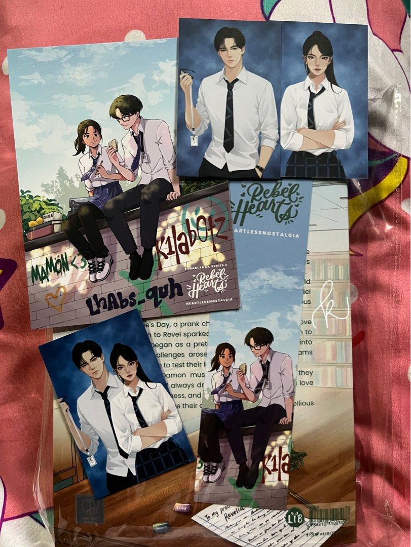 rebel hearts by heartlessnostalgia (Category: Storybooks) located in Naga. Submitted by .akaashi (Listing ID 1462989167, Image 2). Description: rebel hearts by heartlessnostalgia (chennie sandejas) - ₱350 (srp: 500) - bulky edition - signed - brand new, resealed with opp - just opened once to read sc - vvgc - with postcard, bookmark, and 3 photo cards loc: bicol mop: gcash .