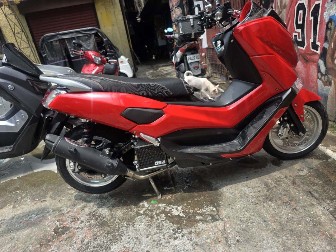 Red Yamaha NMAX (Category: Motorbikes for Sale) located in Manila. Submitted by polengg_whale (Listing ID 1462974387, Image 2). Description: Selling my red Yamaha NMAX. It has a carbon fiber windshield and a custom exhaust. The seat has a unique pattern. Great for city riding. Well maintained and runs smoothly. Ready for a new owner. Message me for more details or to arrange a viewing..