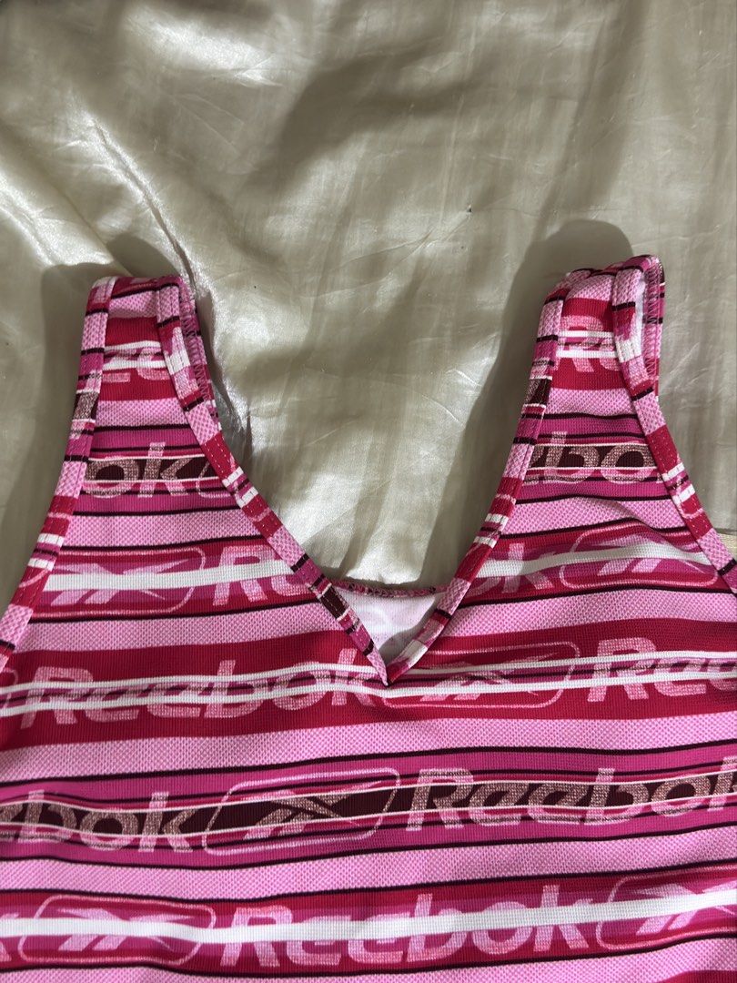 Reebok Pink Striped Tank Top (Category: Sleeveless) located in Legazpi City. Submitted by bouxloset (Listing ID 1463051215, Image 3). Description: - Cute pink and white striped Reebok tank top - All-over Reebok logo print - V-neck with racerback straps - Built-in bra lining for support - Ideal for workouts or casual wear.