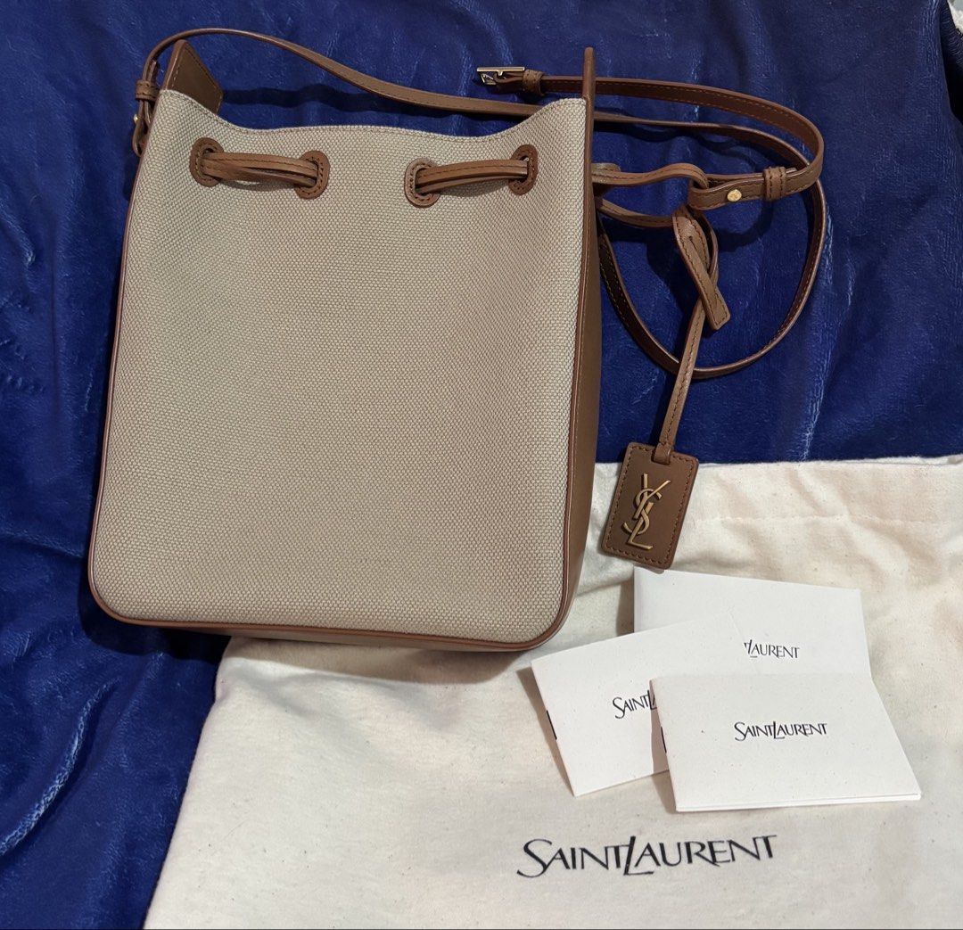 Authentic Saint Laurent Canvas & Leather Bucket Bag (Category: Luxury Bags & Wallets) located in Taytay. Submitted by cel127 (Listing ID 1462944545, Image 1). Description: - Authentic Saint Laurent bucket bag (10000000% authentic) - New model not vintage - Desert dust brick canvas with brown leather trim - Adjustable strap for crossbody (if petite) or shoulder wear - Iconic YSL logo charm - Includes dust bag and care cards - Negotiable for sure b