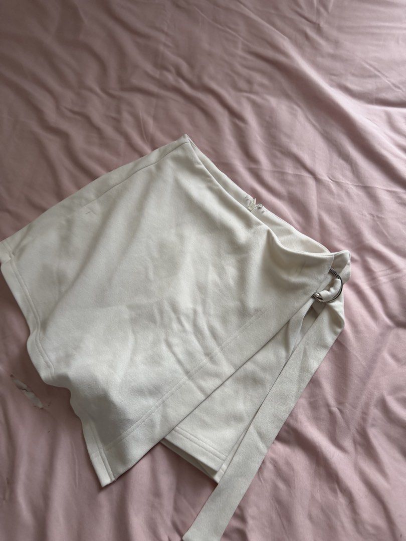 SHEIN White D-Ring Wrap Skort Size M (Category: Shorts) located in Manila. Submitted by leean0924 (Listing ID 1462885593, Image 2). Description: - White skort from SHEIN - Size: Medium (M) - Design: Wrap front with D-ring detail - Closure: Side zipper - Origin: Made in China - Versatile: Suitable for casual outings or dressing up.