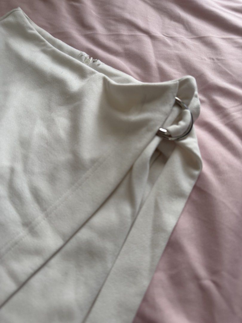 SHEIN White D-Ring Wrap Skort Size M (Category: Shorts) located in Manila. Submitted by leean0924 (Listing ID 1462885593, Image 1). Description: - White skort from SHEIN - Size: Medium (M) - Design: Wrap front with D-ring detail - Closure: Side zipper - Origin: Made in China - Versatile: Suitable for casual outings or dressing up.