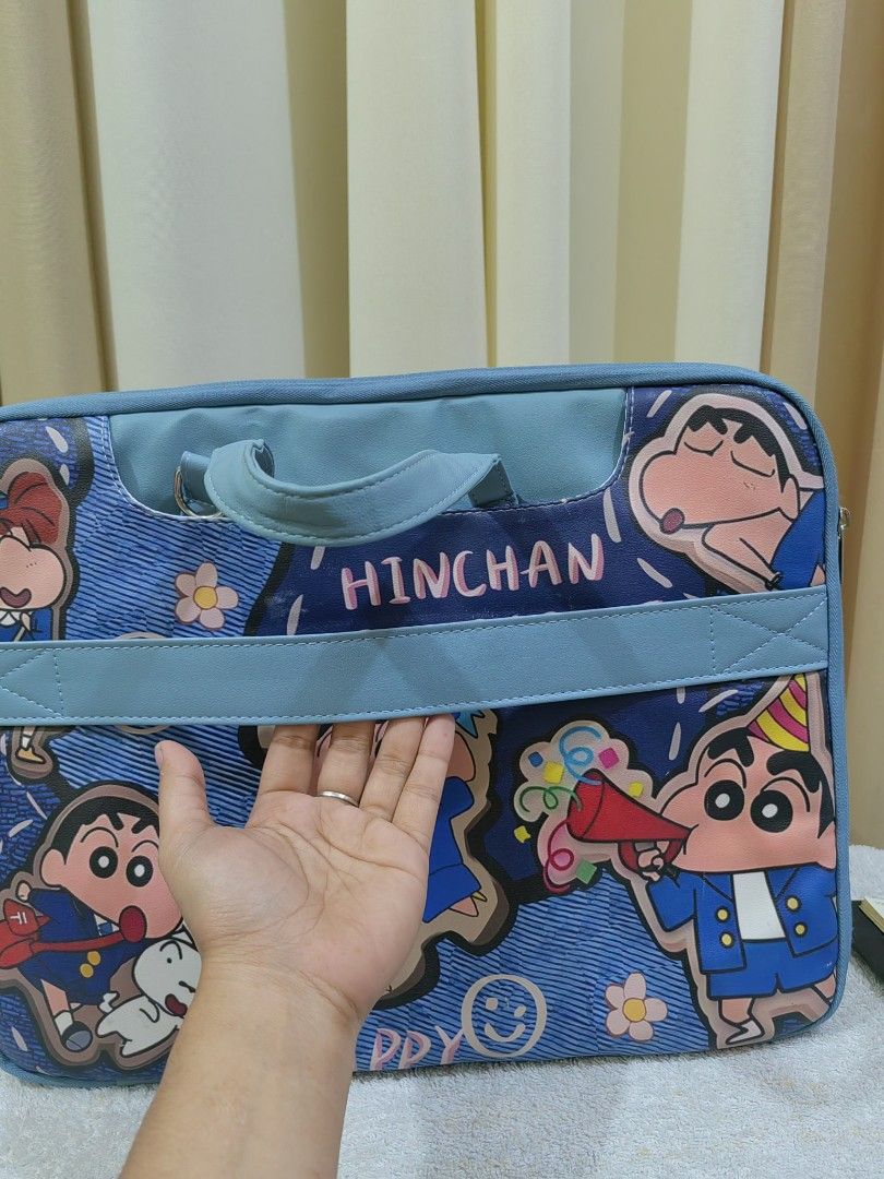Shinchan "Hinchan Rabbit" Laptop Bag (Category: Laptop Bags & Sleeves) located in Makati City. Submitted by prelovedtreatedwithlove (Listing ID 1463002628, Image 3). Description: - Adorable Shinchan themed laptop bag - Durable blue denim-like material - Features various Shinchan character designs - Includes comfortable handles - Detachable shoulder strap for versatile carrying - Multiple internal compartments for organization - Built-in strap to 