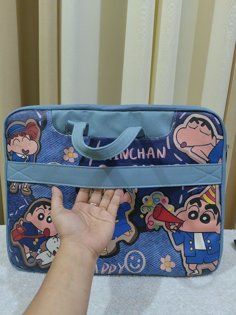 Shinchan "Hinchan Rabbit" Laptop Bag (Category: Laptop Bags & Sleeves) located in Makati City. Submitted by prelovedtreatedwithlove (Listing ID 1463002628, Image 2). Description: - Adorable Shinchan themed laptop bag - Durable blue denim-like material - Features various Shinchan character designs - Includes comfortable handles - Detachable shoulder strap for versatile carrying - Multiple internal compartments for organization - Built-in strap to 