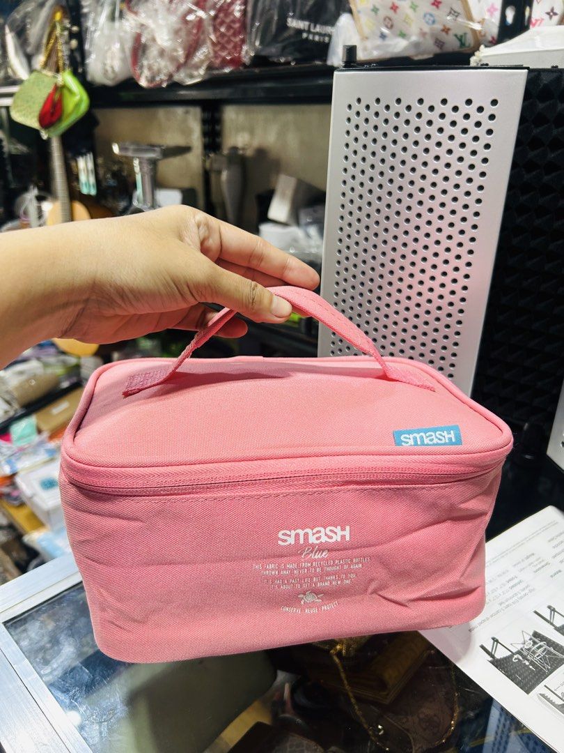 Smash Blue Pink Cosmetic Bag Organizer (Category: Purses & Pouches) located in Manila. Submitted by starbalesukandjapansurplus (Listing ID 1462905587, Image 1). Description: - Pink Smash Blue cosmetic bag - Features a convenient handle - Secure zipper closure - Interior elastic straps for organization - Lined with a shiny blue material - Ideal for makeup or toiletries - Easy to carry for travel or everyday use.