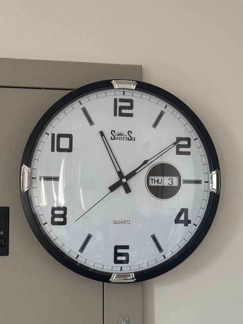 Sonrisa Quartz Wall Clock with Day/Date Display (Category: Clocks) located in Manila. Submitted by ariz.prelovedph (Listing ID 1462907669, Image 1). Description: - Sonrisa quartz wall clock - Clear display: Time, Day, and Date - Stylish black frame with silver accents - In excellent working condition - Battery included - Original Price: 1,749 pesos.