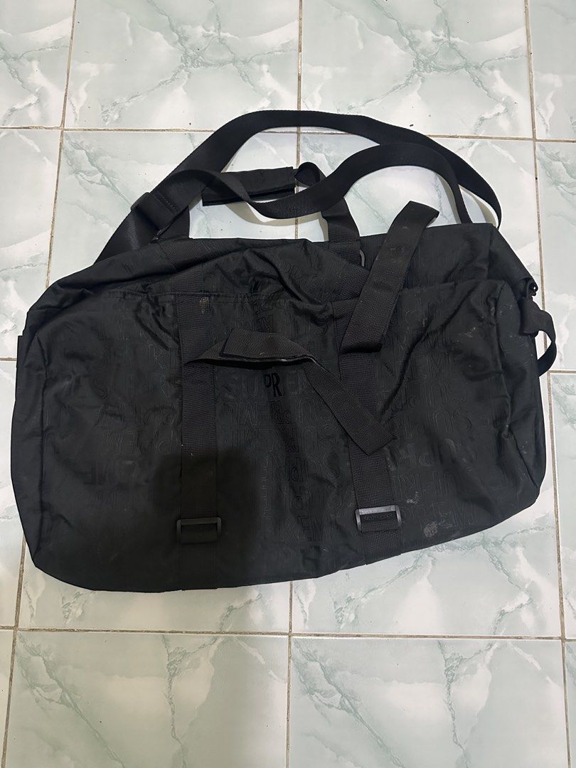 Supreme Black Monogram Duffel Bag (Category: Luxury Bags & Wallets) located in Tagum. Submitted by ritarits572 (Listing ID 1463058435, Image 2). Description: - Black Supreme Duffel Bag - All-over embossed Supreme logo pattern - Dual top handles for easy carrying - Detachable shoulder strap for versatility - Spacious main compartment with secure zipper closure - Convenient side pockets for extra storage - Ideal for travel, gym sessions, or everyda