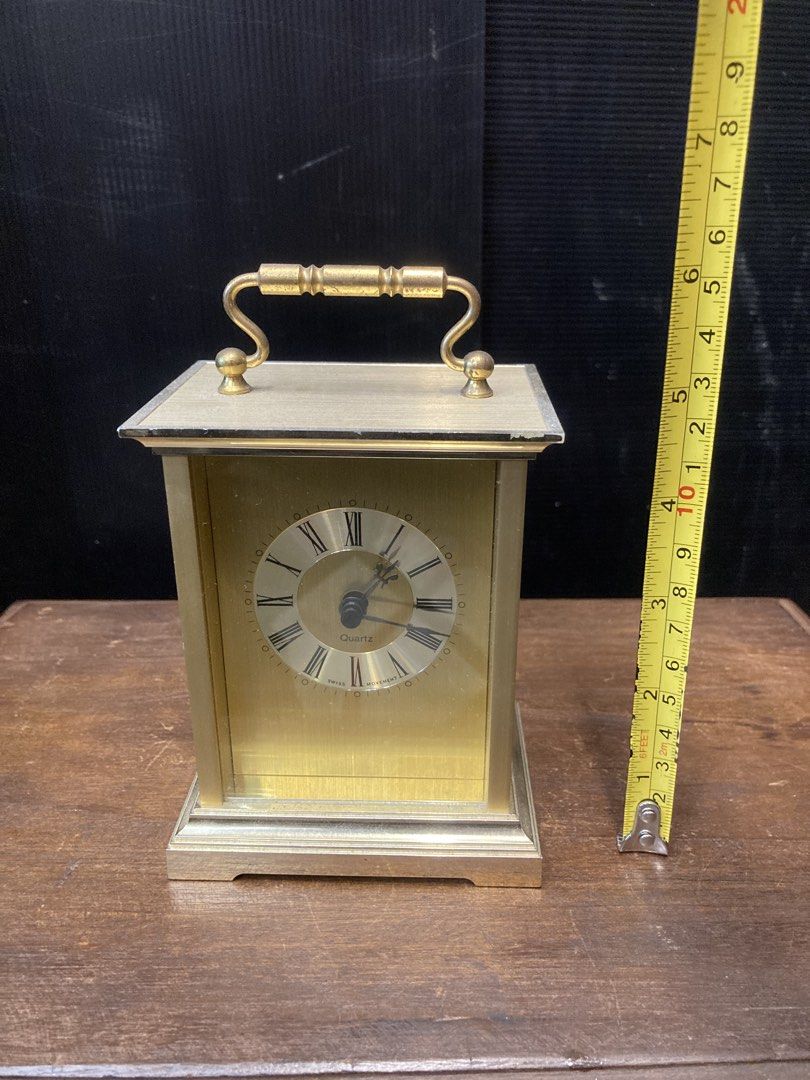 Table clock (Category: Clocks) located in Kuala Lumpur. Submitted by gninevintage (Listing ID 1463085826, Image 3). Description: - Elegant brass carriage clock with a convenient top handle. - Features classic Roman numerals on the clock face. - Reliable Swiss quartz movement for accurate timekeeping. - Battery operated for easy use. - Stands approximately 7 inches tall. - In excellent working condition..