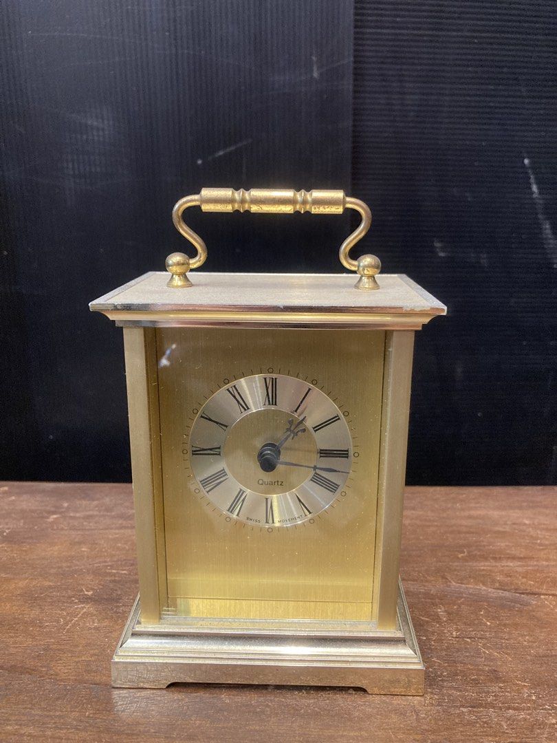 Table clock (Category: Clocks) located in Kuala Lumpur. Submitted by gninevintage (Listing ID 1463085826, Image 1). Description: - Elegant brass carriage clock with a convenient top handle. - Features classic Roman numerals on the clock face. - Reliable Swiss quartz movement for accurate timekeeping. - Battery operated for easy use. - Stands approximately 7 inches tall. - In excellent working condition..