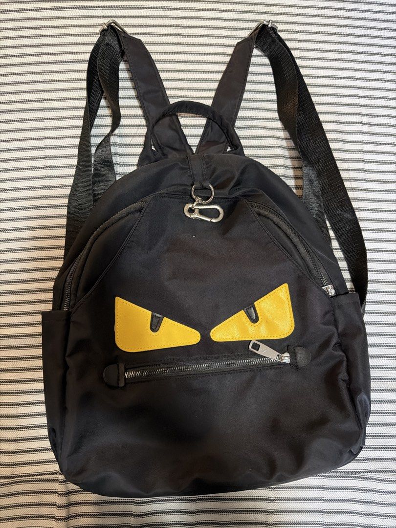 (Take all) Black Backpack & Black Nylon Tote Bag (Category: Tote Bags) located in Manila. Submitted by mondaymom (Listing ID 1462984788, Image 2). Description: - Black backpack with fun monster eye design - Multiple zippers and adjustable straps on backpack - Includes a black tote bag with a pocket - Tote bag features a snap closure - Both bags made of nylon material - Ideal for everyday use or travel.