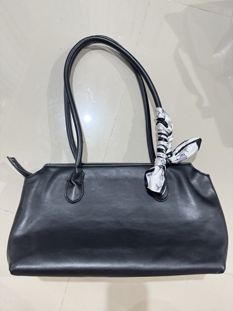The Row Leather Terrase Shoulder Bag Black (Category: Luxury Bags & Wallets) located in Bacolod City. Submitted by matahum.bcd (Listing ID 1463061025, Image 2). Description: - The Row Terrase shoulder bag - Material: Black calfskin leather - Features a stylish scarf tied to the handle - Interior includes zippered pockets for organization - Ideal for everyday use .