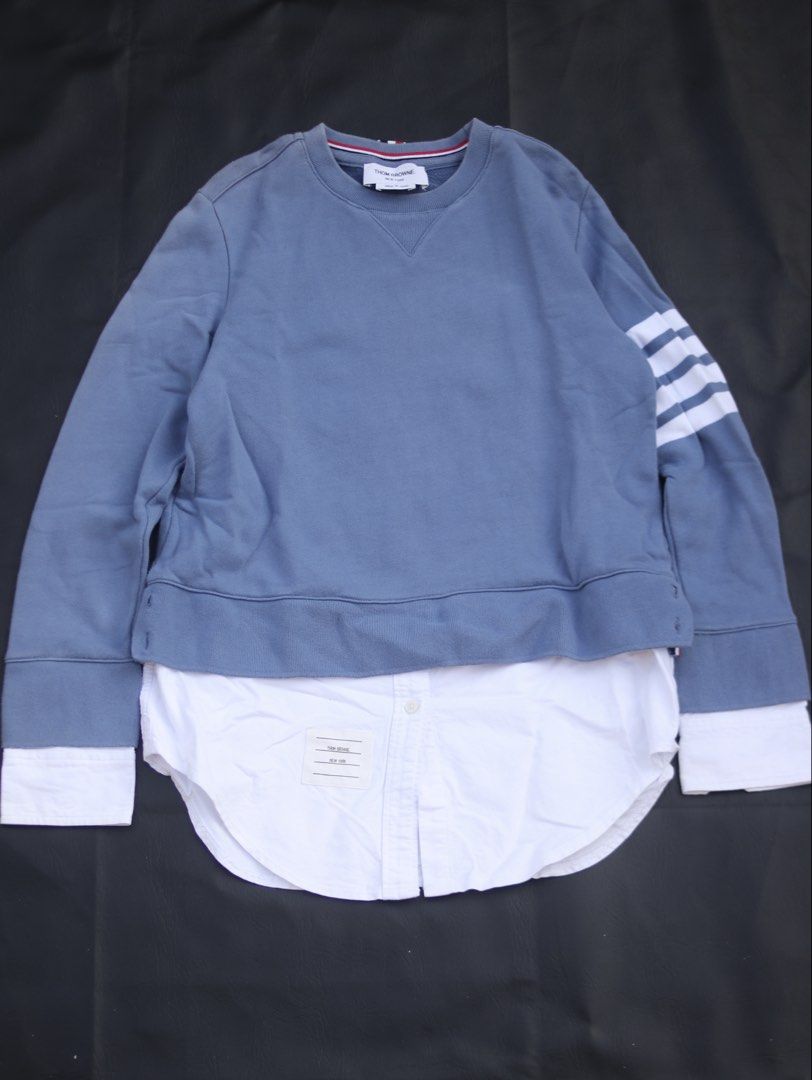 Thom Browne Blue Sweatshirt with White Shirt Layer (Category: Luxury Apparel) located in Taguig. Submitted by kurim4w (Listing ID 1463002809, Image 1). Description: - Blue sweatshirt with integrated white shirt layer - Iconic Thom Browne four-stripe detail on sleeve -fading in shoulder - Made in Japan - Tag size: 40 - Ideal for creating stylish layered outfits - Crafted from comfortable cotton material 17.5width 27length 550php only plus sf tagui