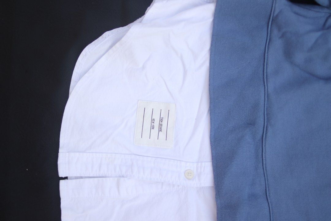 Thom Browne Blue Sweatshirt with White Shirt Layer (Category: Luxury Apparel) located in Taguig. Submitted by kurim4w (Listing ID 1463002809, Image 2). Description: - Blue sweatshirt with integrated white shirt layer - Iconic Thom Browne four-stripe detail on sleeve -fading in shoulder - Made in Japan - Tag size: 40 - Ideal for creating stylish layered outfits - Crafted from comfortable cotton material 17.5width 27length 550php only plus sf tagui