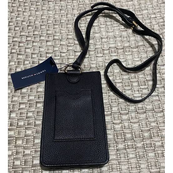 Tommy Hilfiger Black Leather Phone Pouch with Strap (Category: Purses & Pouches) located in Quezon City. Submitted by decluttering.mommy (Listing ID 1463003528, Image 2). Description: - Genuine black leather phone pouch by Tommy Hilfiger - Adjustable long strap for comfortable wear - Iconic Tommy Hilfiger logo prominently displayed on the front - Convenient card slot on the back for essentials - Brand new with original tag attached - Ideal for ke