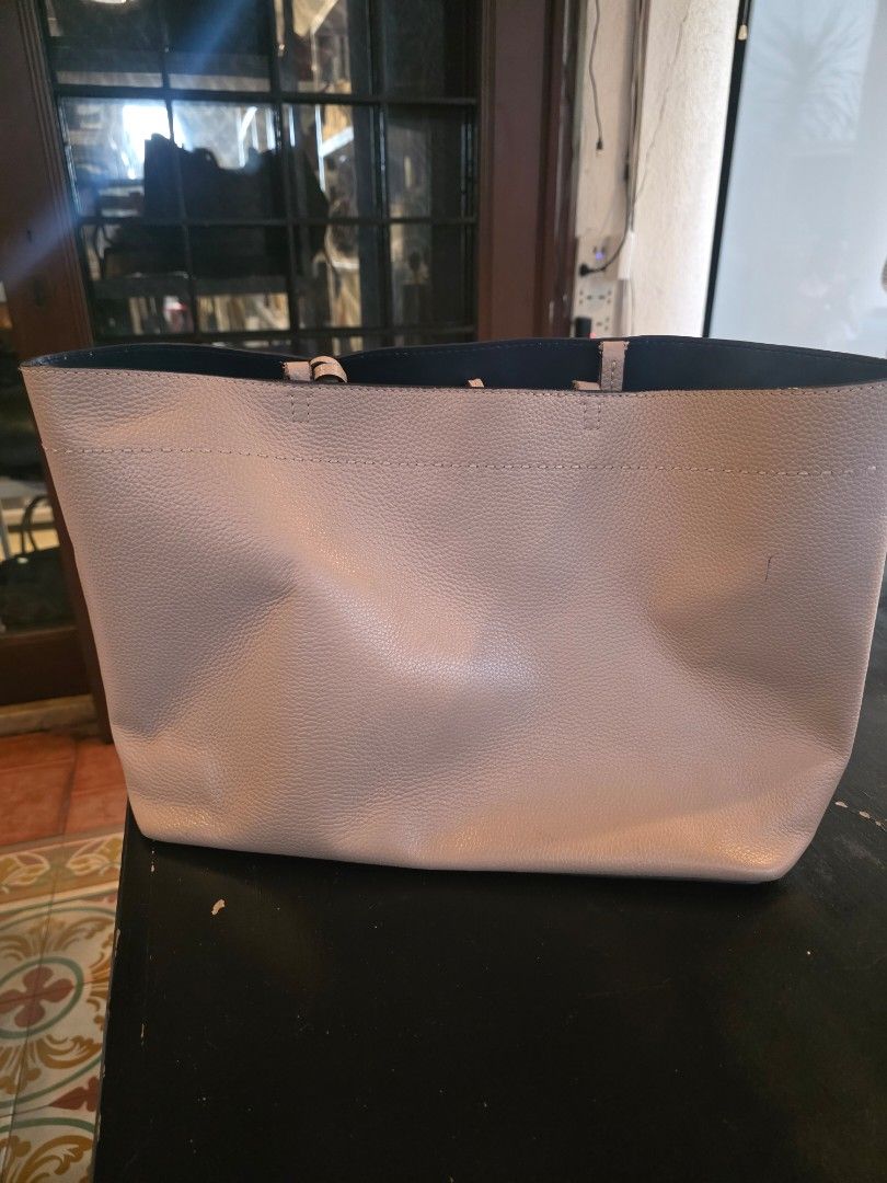 Tory Burch Perforated Leather Tote Bag (Category: Luxury Bags & Wallets) located in Makati City. Submitted by joeyrscott (Listing ID 1462965469, Image 2). Description: - Tory Burch tote bag, authentic - Devon Sand color - Pebbled leather exterior with signature logo - Gold-tone hardware - Slight wear on corners and some pen marks - Great for everyday use - Comes with original dust bag.