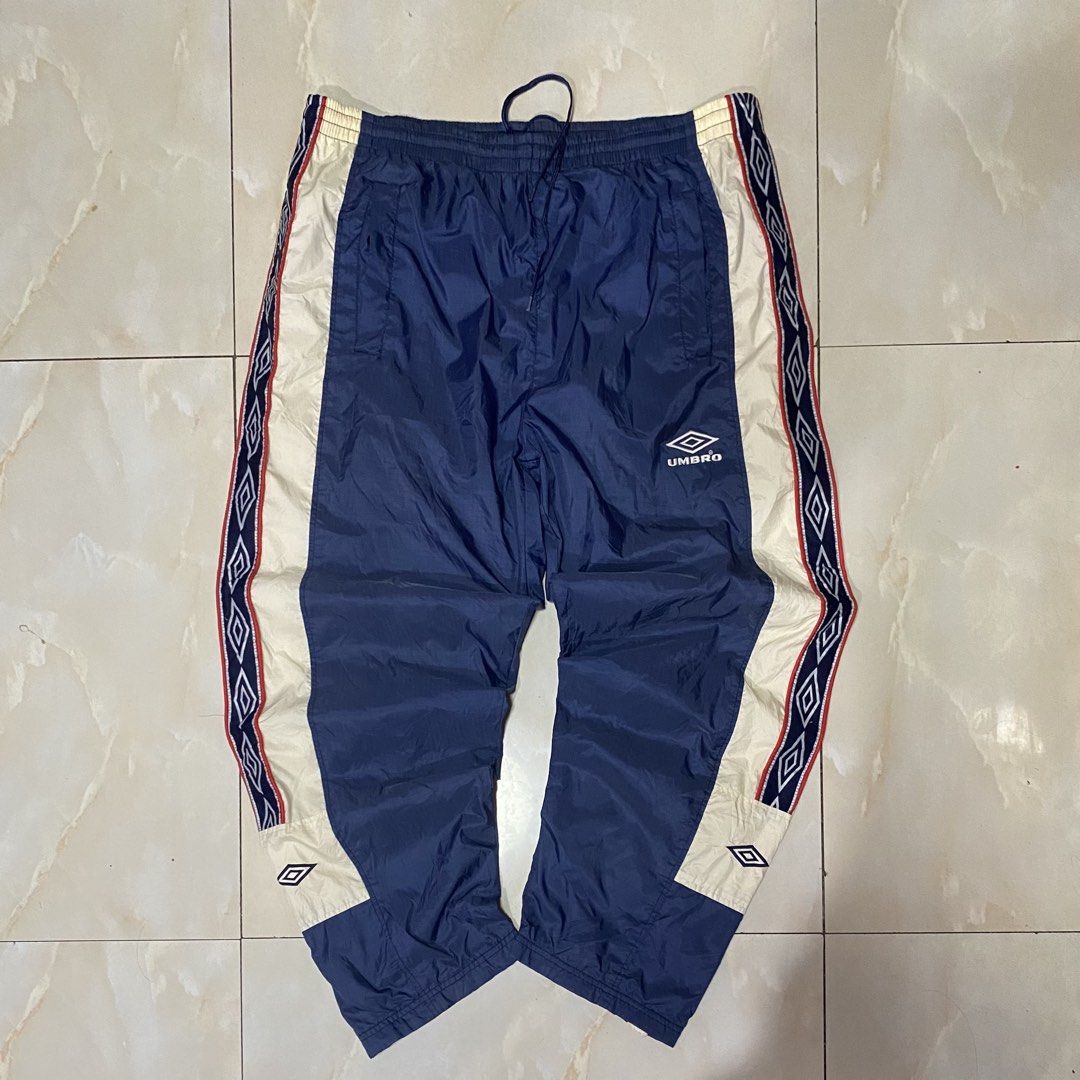 Umbro Vintage Track Pants Snap Button Side (Category: Joggers) located in Quezon City. Submitted by mgc_thriftshop (Listing ID 1462947239, Image 1). Description: - Vintage Umbro track pants - Size XL - Navy blue with cream and red side stripes - Full snap button closure on legs - Elastic waistband with drawstring - Umbro logo embroidered on left leg VTG umbro track pants size xl waistline 36 thigh 14.5 length 40 Hem 9 no issue excellent condition