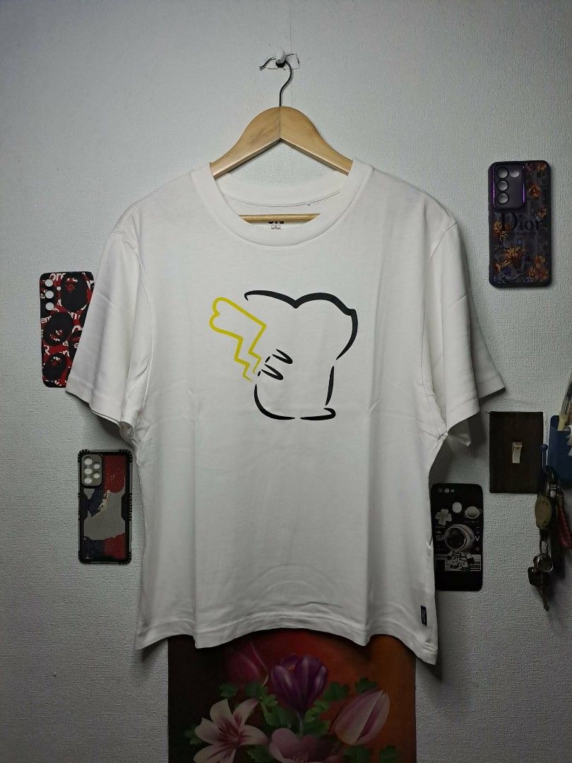 UT Uniqlo x Pikachu x Pokèmon (Category: Shirts) located in Manila. Submitted by yaseen__73 (Listing ID 1463058588, Image 1). Description: "With Pokémon" UT collection by UNIQLO. Released as part of a 2020 collaborative capsule, the shirt features a minimalist line-art design outlining the back silhouette of a female Pikachu (identifiable by the heart-shaped notch at the end of its lightning-bolt tail). - Small on Tag - Dimensions : See Photo - C