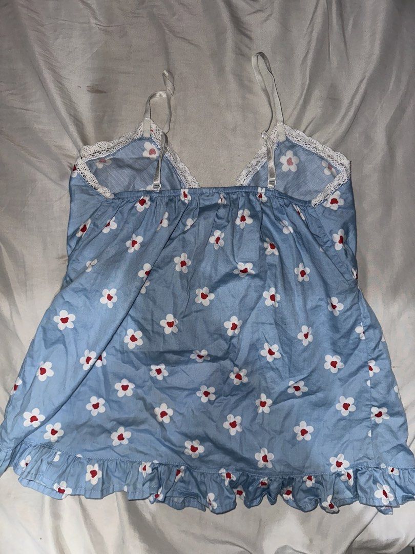 Vesconki Blue Daisy Print Top (Category: Sleeveless) located in Manila. Submitted by etain.xo (Listing ID 1463008736, Image 2). Description: - Adorable blue top with a charming daisy print. - Features delicate white lace trim. - Sweet red bow details on the straps. - Convenient button-up front closure. - Flirty ruffled hemline. - Fits small to medium.