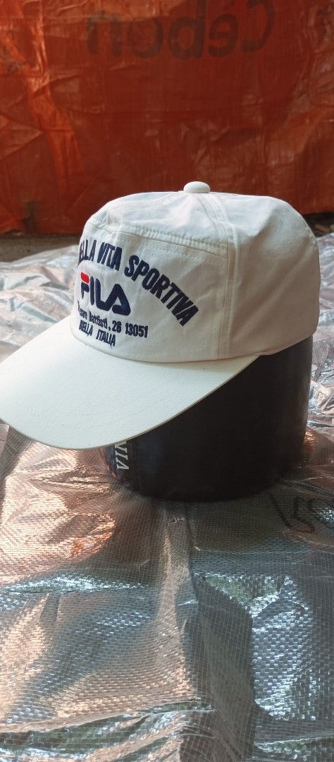 Vintage Fila Snapback Cap (Category: Caps & Hats) located in Quezon City. Submitted by mangthrift (Listing ID 1463039686, Image 3). Description: - Vintage white FILA baseball cap - Features 'Moda Nella Vita Sportiva' text and FILA logo on the front - Includes Italian address: 'Via Cesare Battisti, 26 13051 Biella Italia' - Small FILA logo detail on the back - No issue Snap - Ideal for everyday casual wear.
