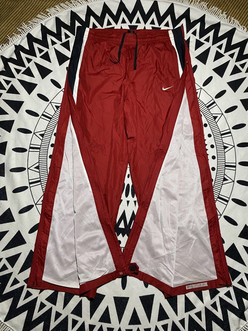 Vintage Nike Red Track Pants Snap Button Sides (Category: Joggers) located in Badiangan. Submitted by iralorana.thrift (Listing ID 1462930741, Image 2). Description: - Classic red Nike track pants - Iconic Nike swoosh logo - Side snap buttons for easy wear - Elastic waistband with drawstring for adjustable fit - Side stripe detail for a sporty look - Ideal for sports or casual outfits.