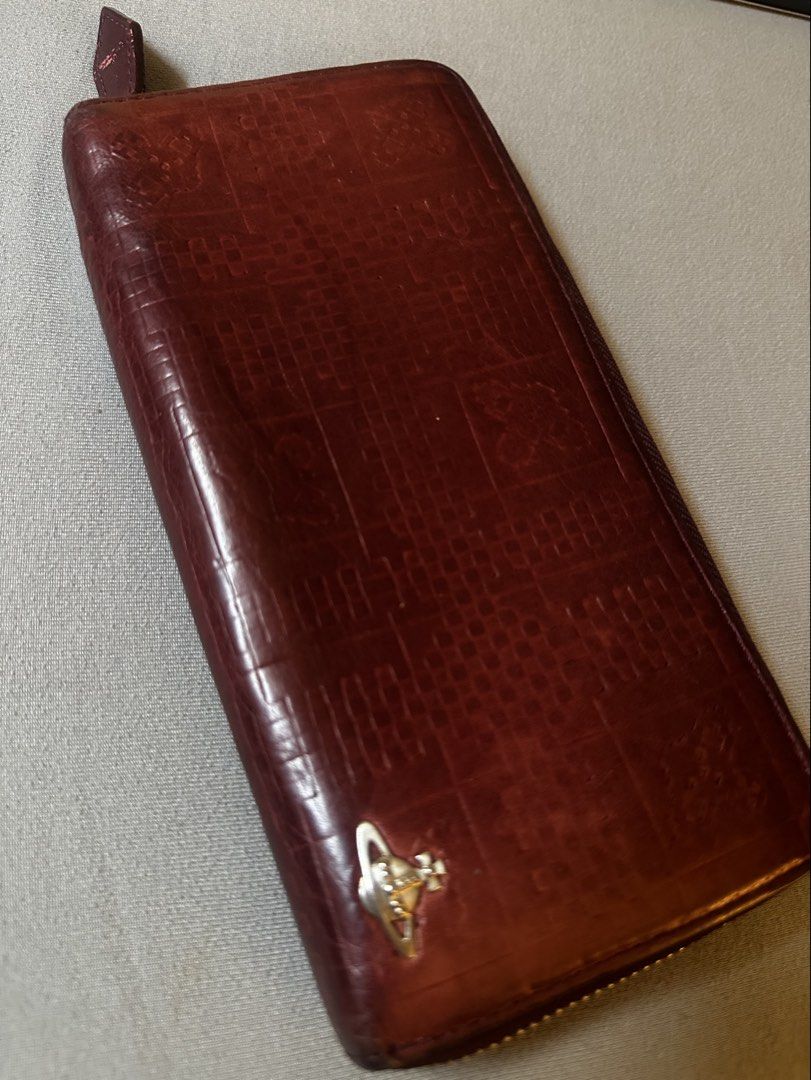 Vivienne Westwood Leather Long Wallet (Category: Luxury Bags & Wallets) located in Manila. Submitted by declutterthisandthat (Listing ID 1462889623, Image 2). Description: - Vivienne Westwood long wallet - Rich burgundy red leather - Elegant embossed pattern - Iconic orb logo on the front - Spacious interior with multiple card slots and compartments - Secure zipper closure - Perfect for keeping your essentials organized.