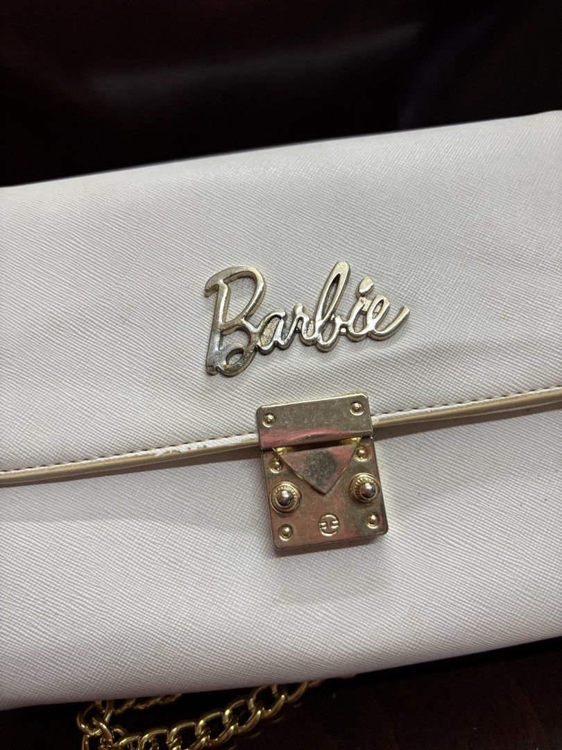 White Barbie Chain Shoulder Bag (Category: Shoulder Bags) located in Manila. Submitted by robbyrabbit (Listing ID 1462914126, Image 2). Description: - Cute white shoulder bag - Gold chain strap - "Barbie" logo in gold lettering - Secure clasp closure - Multiple interior compartments for organization - Ideal for evenings out or adding a playful touch to your style.
