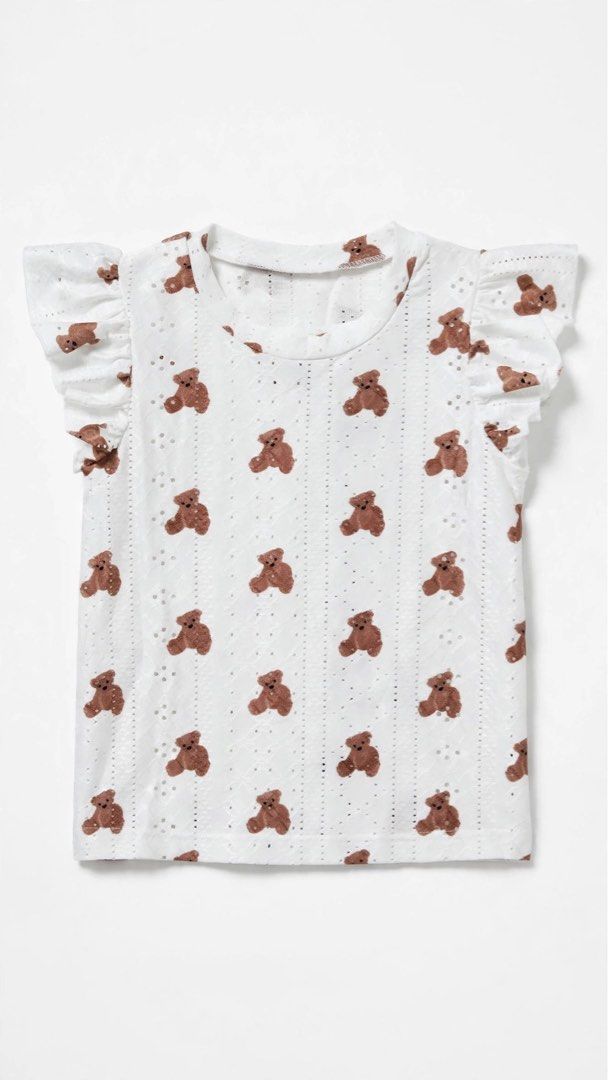 White Eyelet Top with Brown Teddy Bear Print (Category: Babies & Kids Fashion) located in Santa Rosa. Submitted by _allgoodstuff (Listing ID 1463029843, Image 1). Description: - Adorable white top with a charming repeating brown teddy bear print. - Features delicate eyelet detailing for a touch of elegance. - Flattering flutter sleeves add a feminine flair. - Ideal for creating a sweet and casual outfit. - Effortlessly pairs with your favorite sh