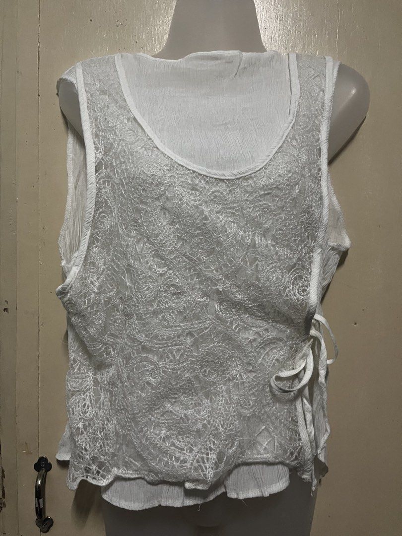 White Lace Overlay Sleeveless Tie-Side Top (Category: Sleeveless) located in Tabuk. Submitted by zenwolf-1867 (Listing ID 1463052930, Image 1). Description: - White sleeveless top - Delicate lace overlay with intricate pattern - Crinkled texture on inner layer - Tie-side closure - Lightweight and airy - Versatile: great for layering or wearing alone.