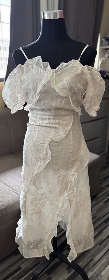 White Ruffled Off-Shoulder Dress with Textured Floral Pattern (Category: Dresses) located in Caloocan City. Submitted by niki.niki. (Listing ID 1463053656, Image 1). Description: - Elegant white dress - Ruffled off-shoulder sleeves - Textured floral pattern fabric - Cinched waist with a flowing skirt - Cascading ruffle details down the front - Ideal for special occasions or chic daytime looks - Unique and eye-catching design.
